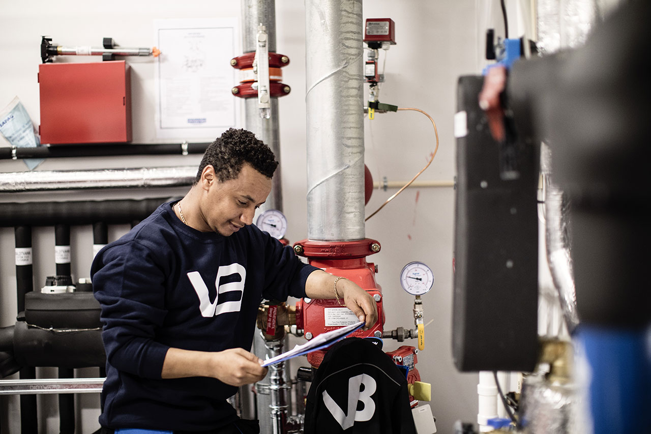 VB rørlegger ser på et skjema ved en vannmåler